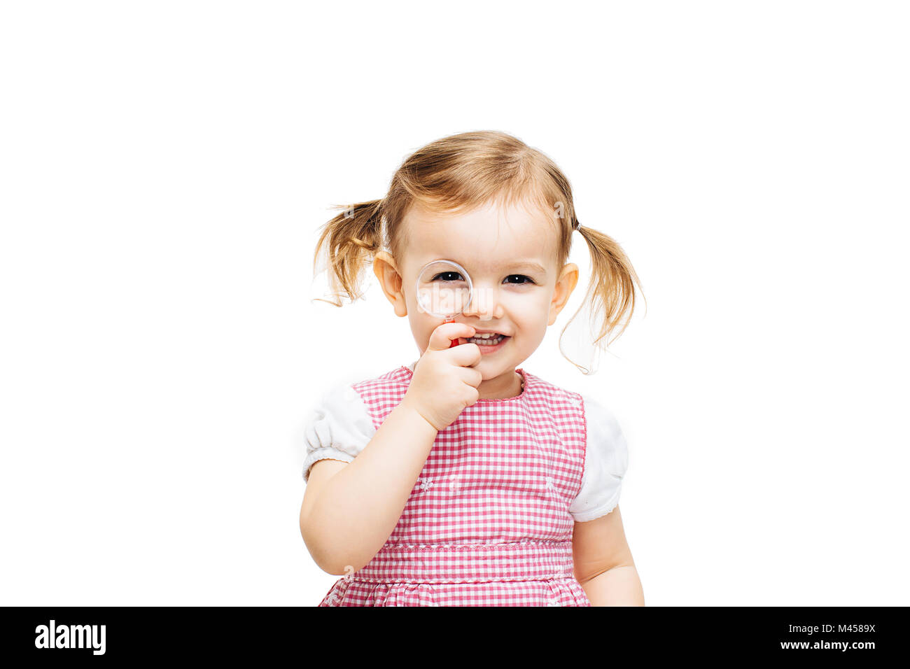Toddler girl with magnifying glass Stock Photo