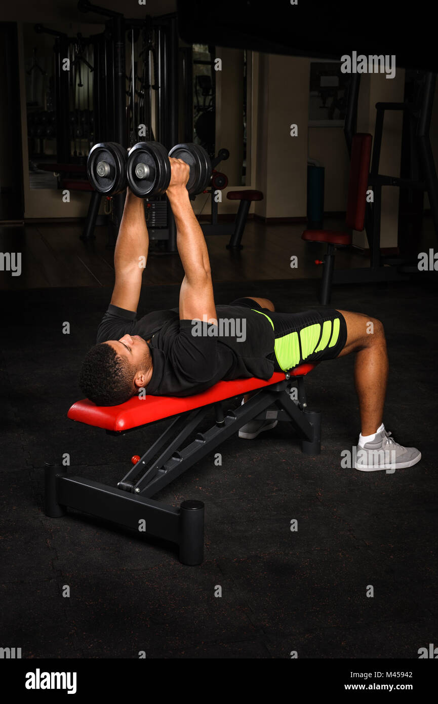 Young man doing arms bench flies workout in gym Stock Photo