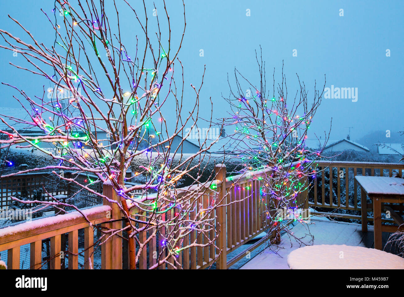 Christmas lights on a balcony of a house in Ambleside in snow. Stock Photo