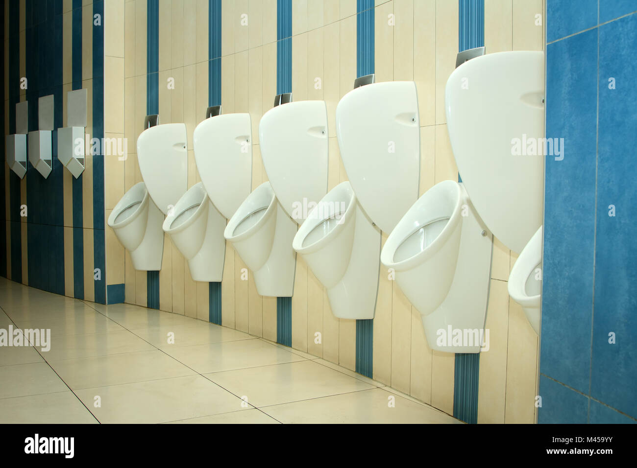 modern restroom interior with urinal row Stock Photo