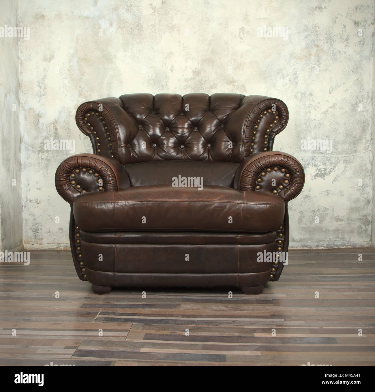 Old vintage brown leather chair in empty room Stock Photo
