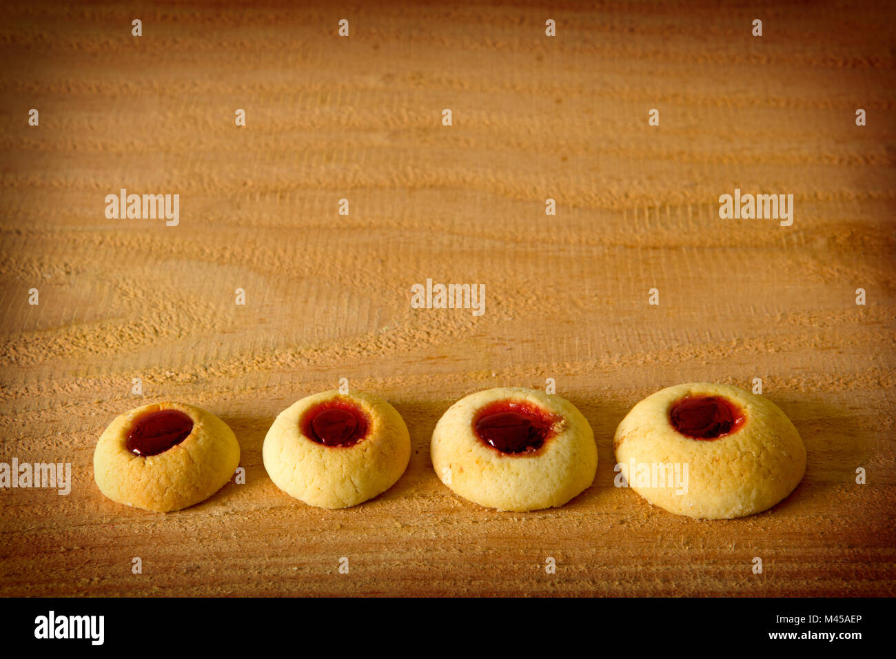 Angel Eyes biscuits with jam isolated on wood background. Stock Photo