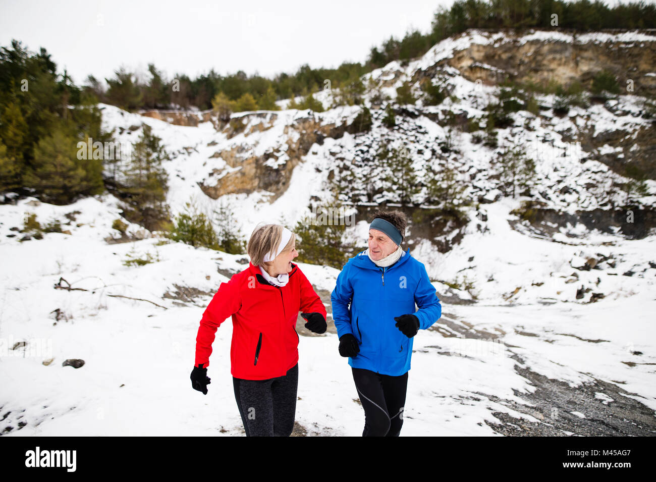 Senior couple jogging in winter nature. Stock Photo