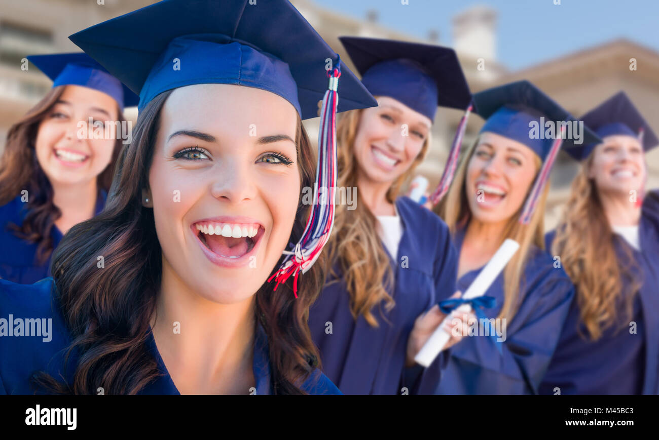 Happy Graduating Group of Girls In Cap and Gown Celebrating on Campus