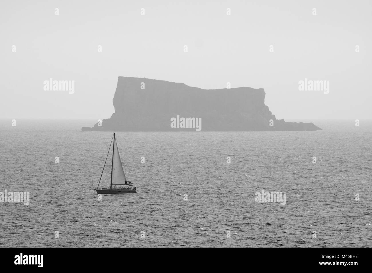 High angle view to a sailboat and a distant rocky island (Filfla, Malta). Stock Photo