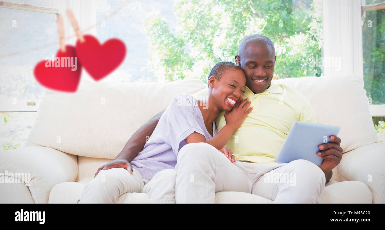 Composite image of happy smiling couple using laptop on couch Stock ...