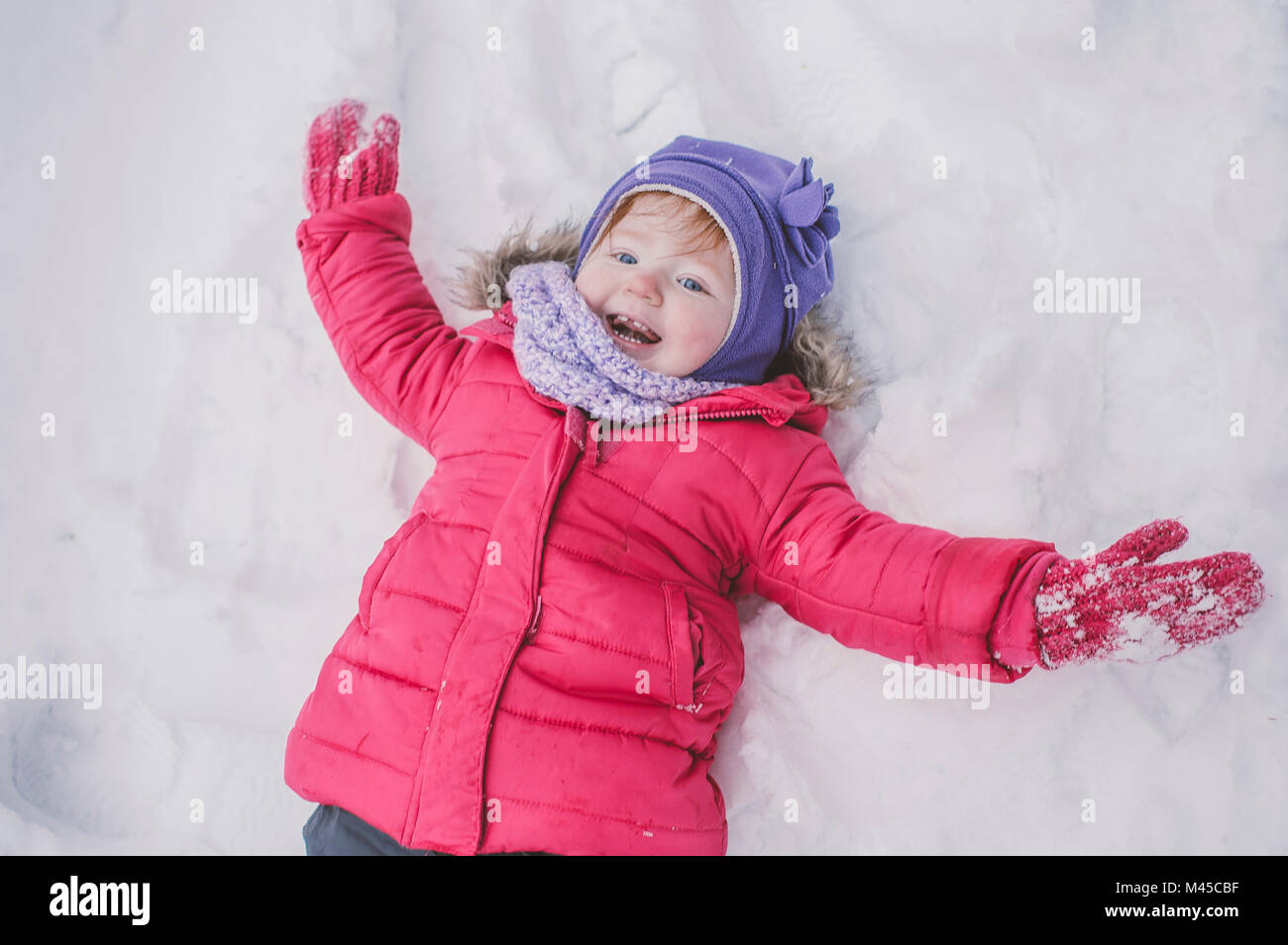 Young girl making snow angel in snow, closeup Stock Photo Alamy