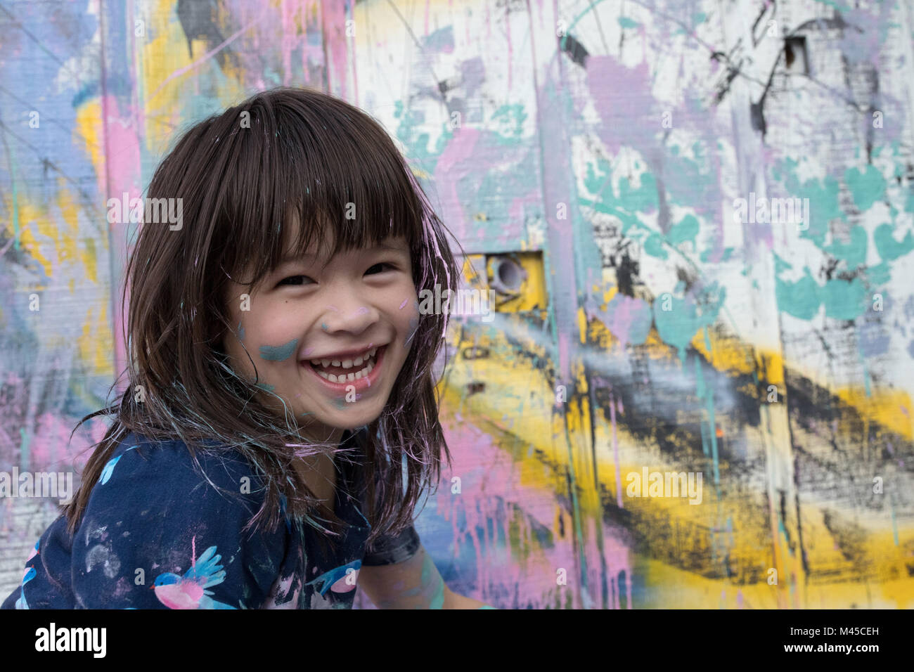 Portrait of girl by painted wall looking at camera smiling Stock Photo ...