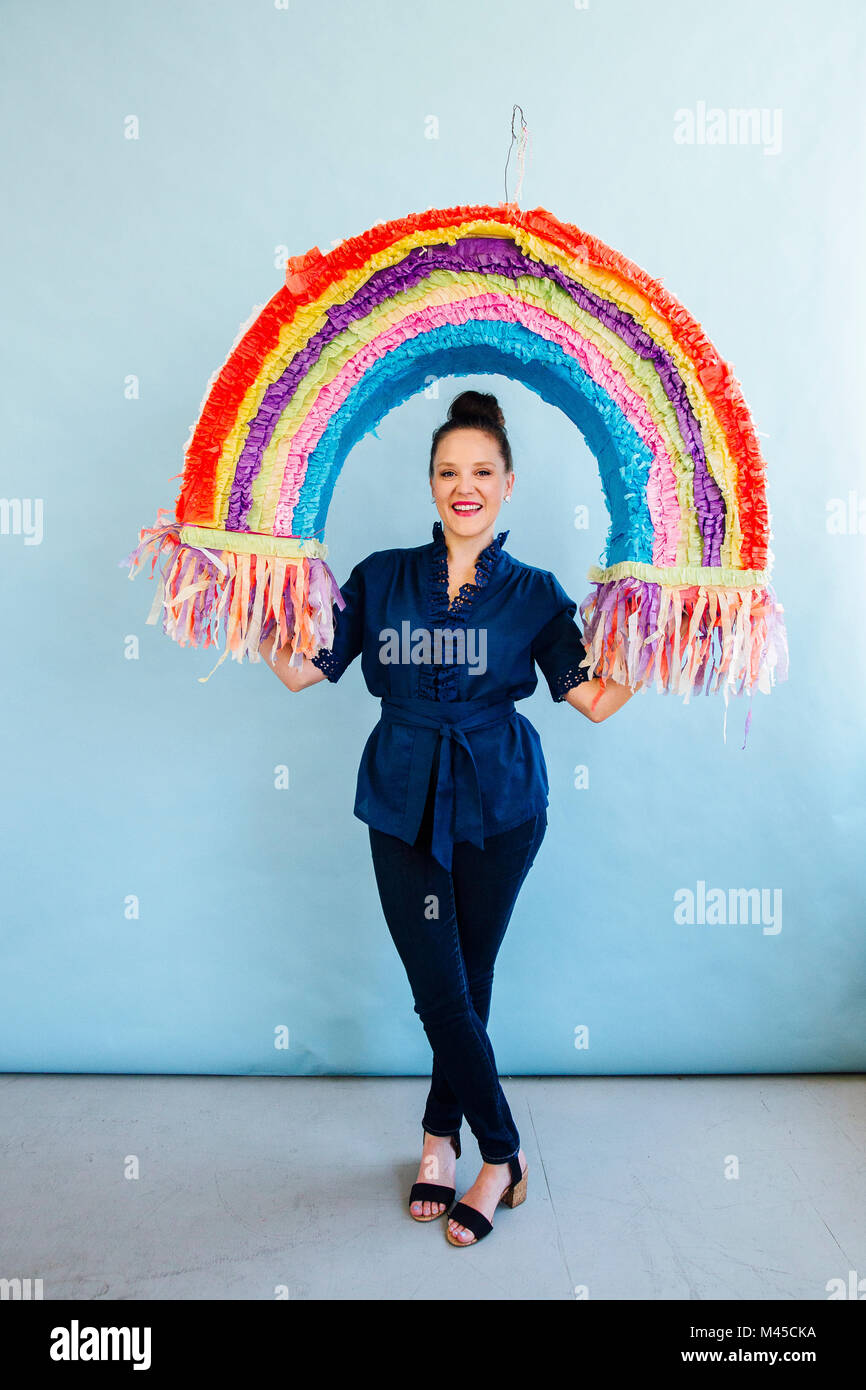 Woman holding rainbow pinata Stock Photo - Alamy