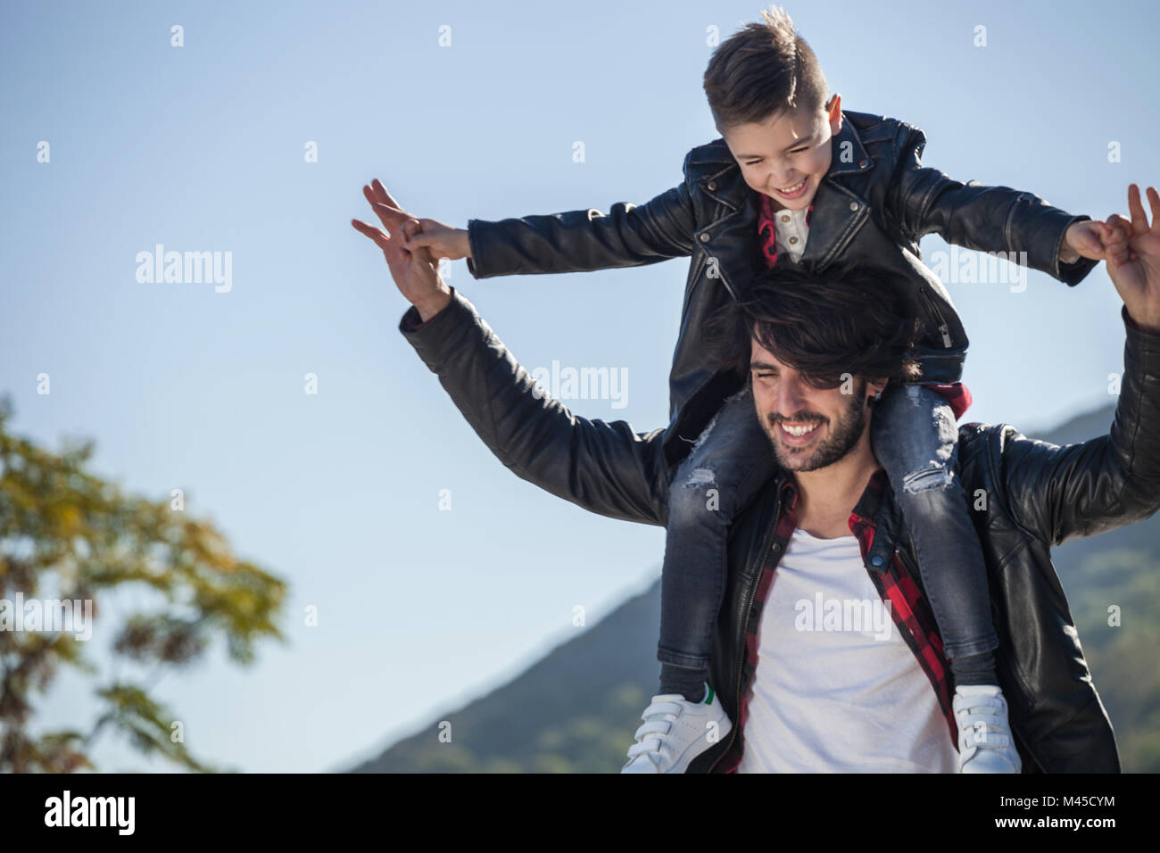 Father and son outdoors, father carrying son on shoulders Stock Photo