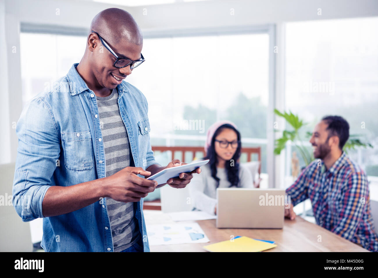 Young businessman using digital tablet while standing in office Stock ...