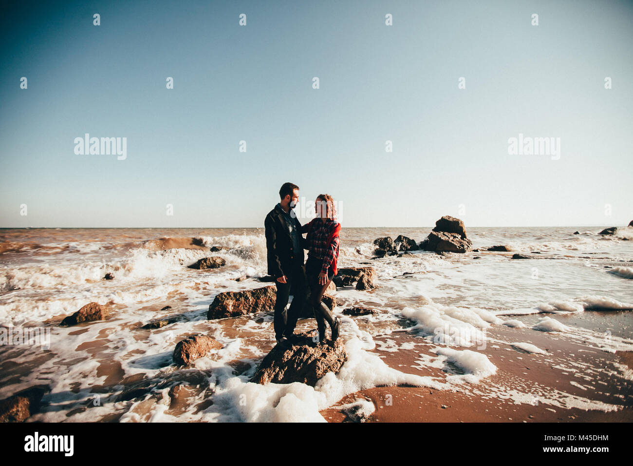 Mid adult couple standing on sea rock, Odessa Oblast, Ukraine Stock Photo