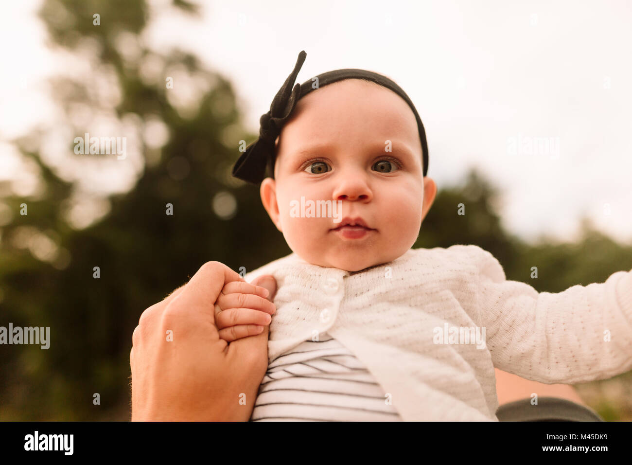 Portrait of baby girl holding mothers hand, close up Stock Photo