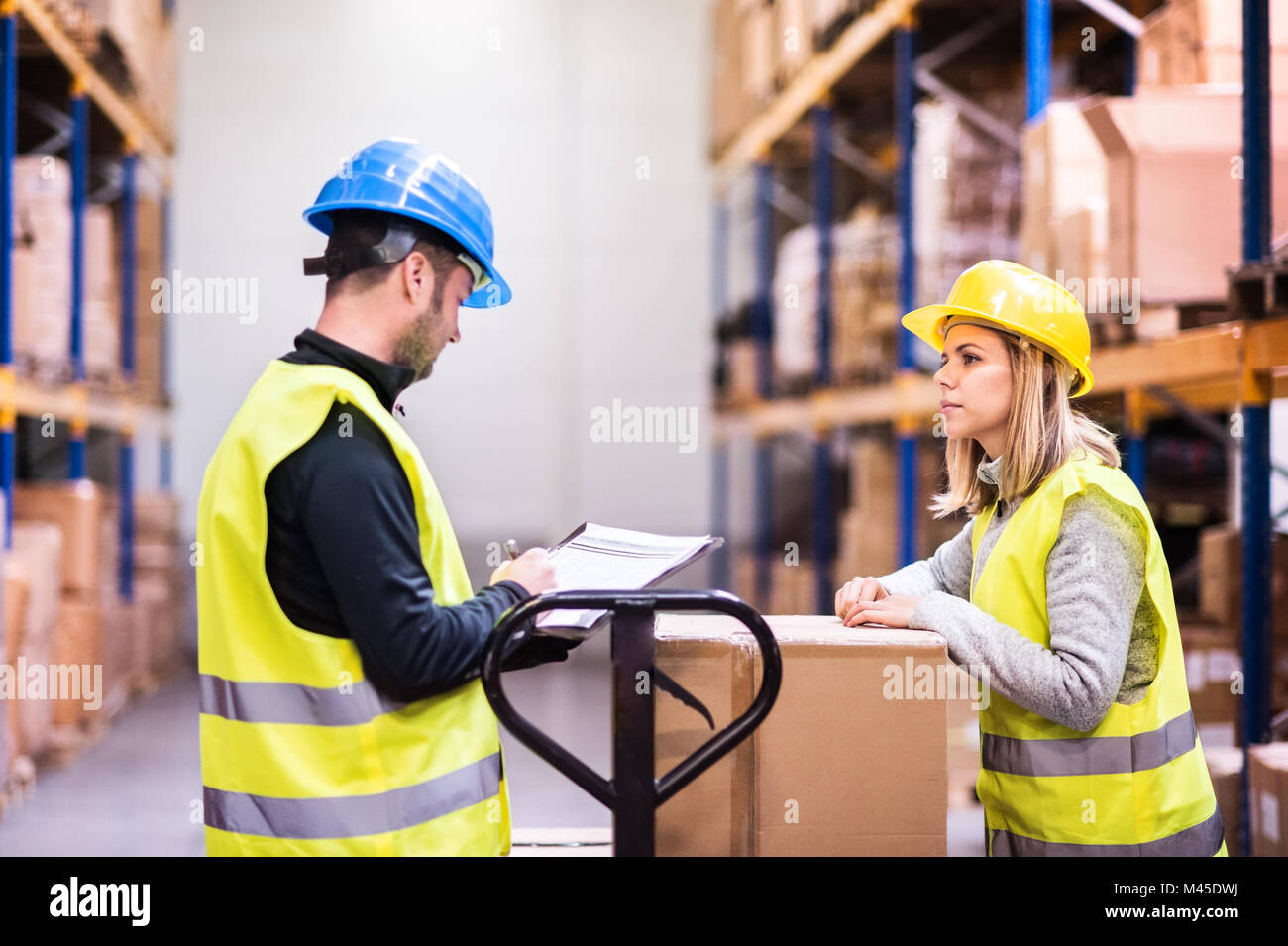 Young warehouse workers working together Stock Photo - Alamy