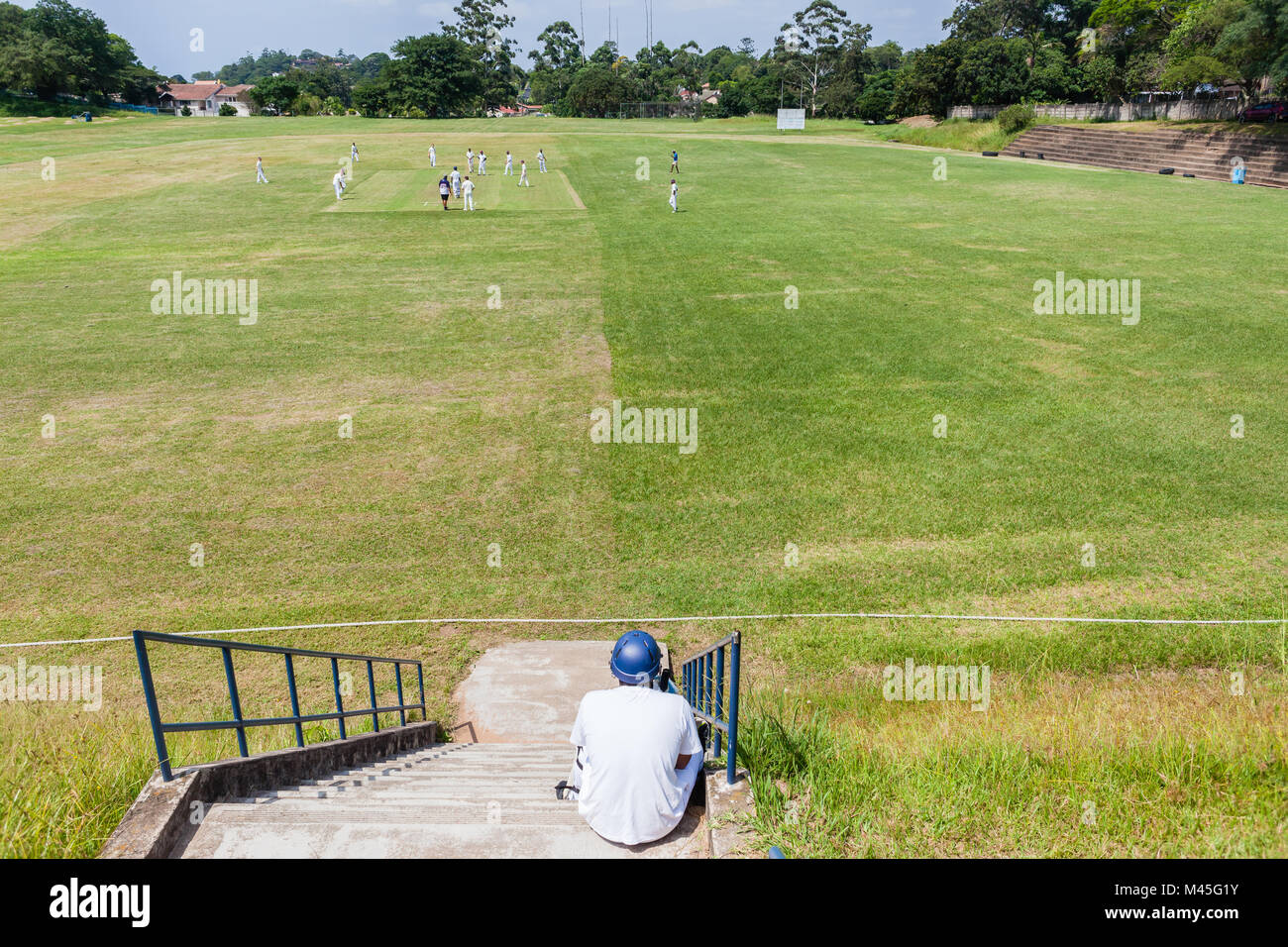 Cricket game high schools teenagers batsman waits on steps above