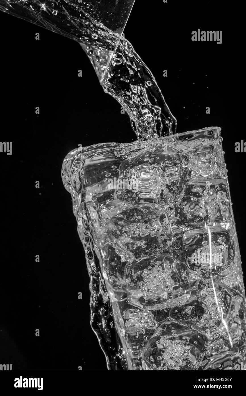 sparkling water overflow over ice cubes Stock Photo Alamy