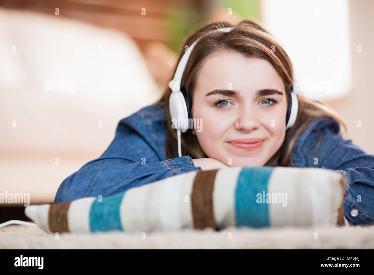 Pretty woman listening music lying on the floor Stock Photo - Alamy