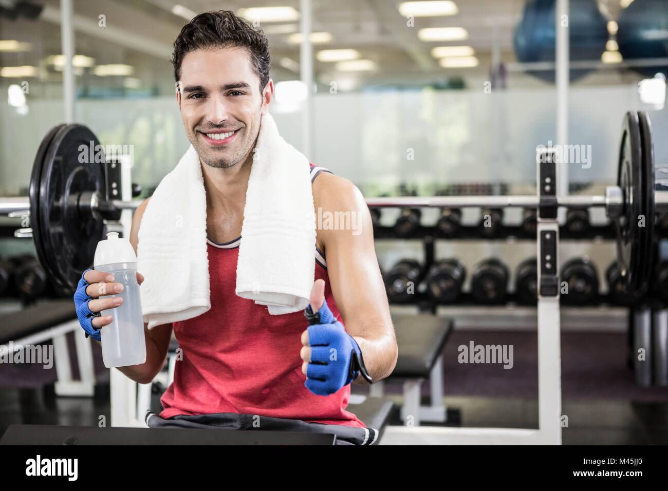 Smiling man showing thumb up and holding bottle of water Stock Photo ...