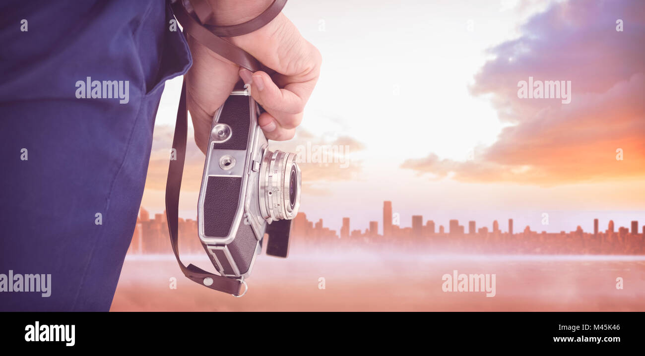 Composite image of cropped image of hipster holding camera Stock Photo