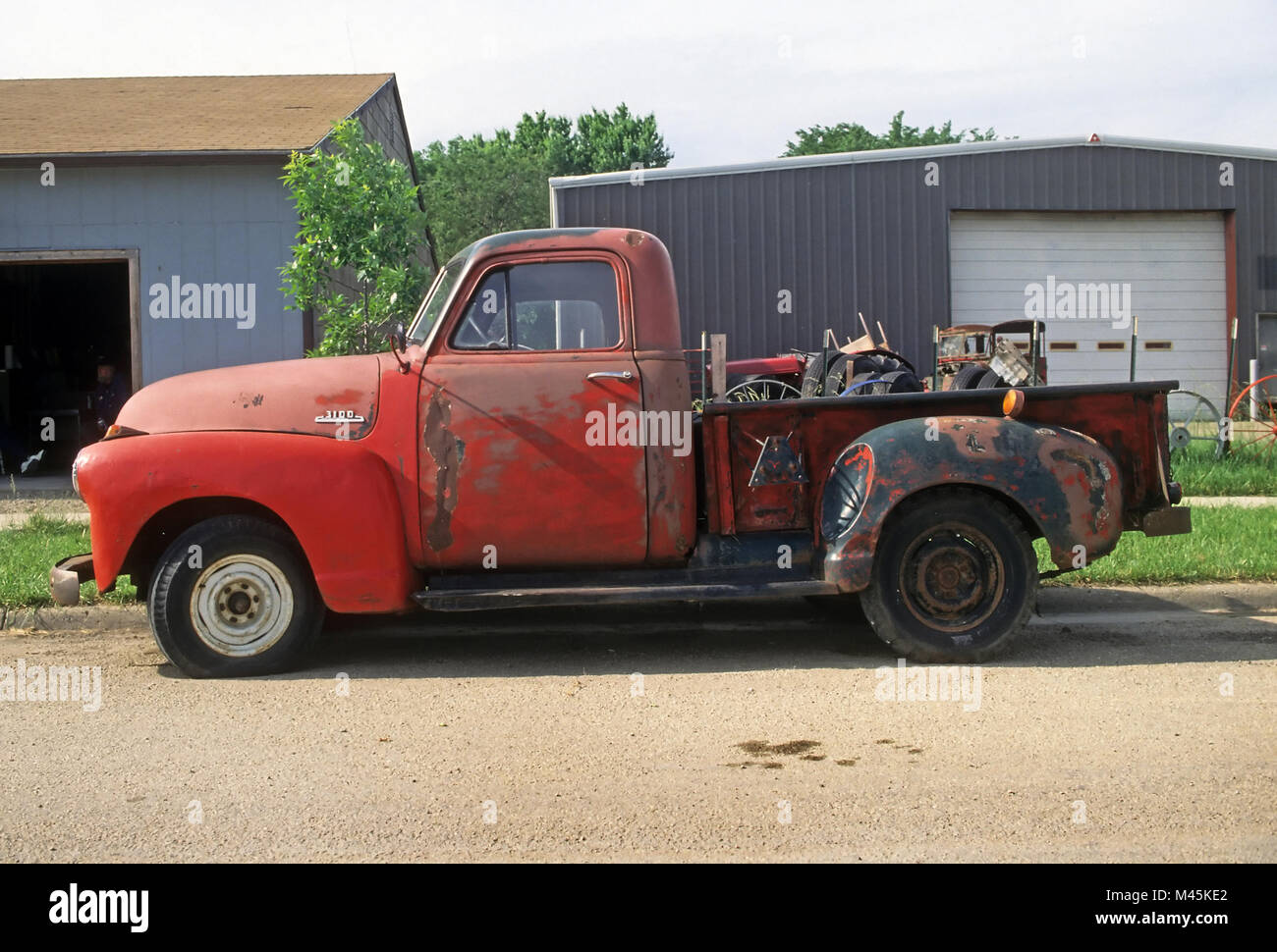 Hoyte, Kansas, USA - April 9, 2014: A battered red 1953 Chevy 3100 half-ton pickup truck in need of restoration parked on a rural road. Stock Photo