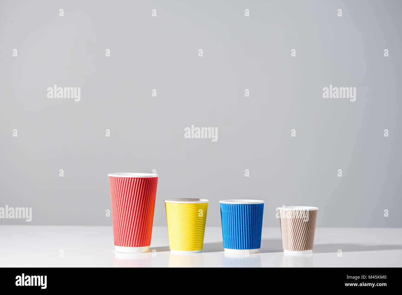 various colored paper cups in a row on grey Stock Photo Alamy