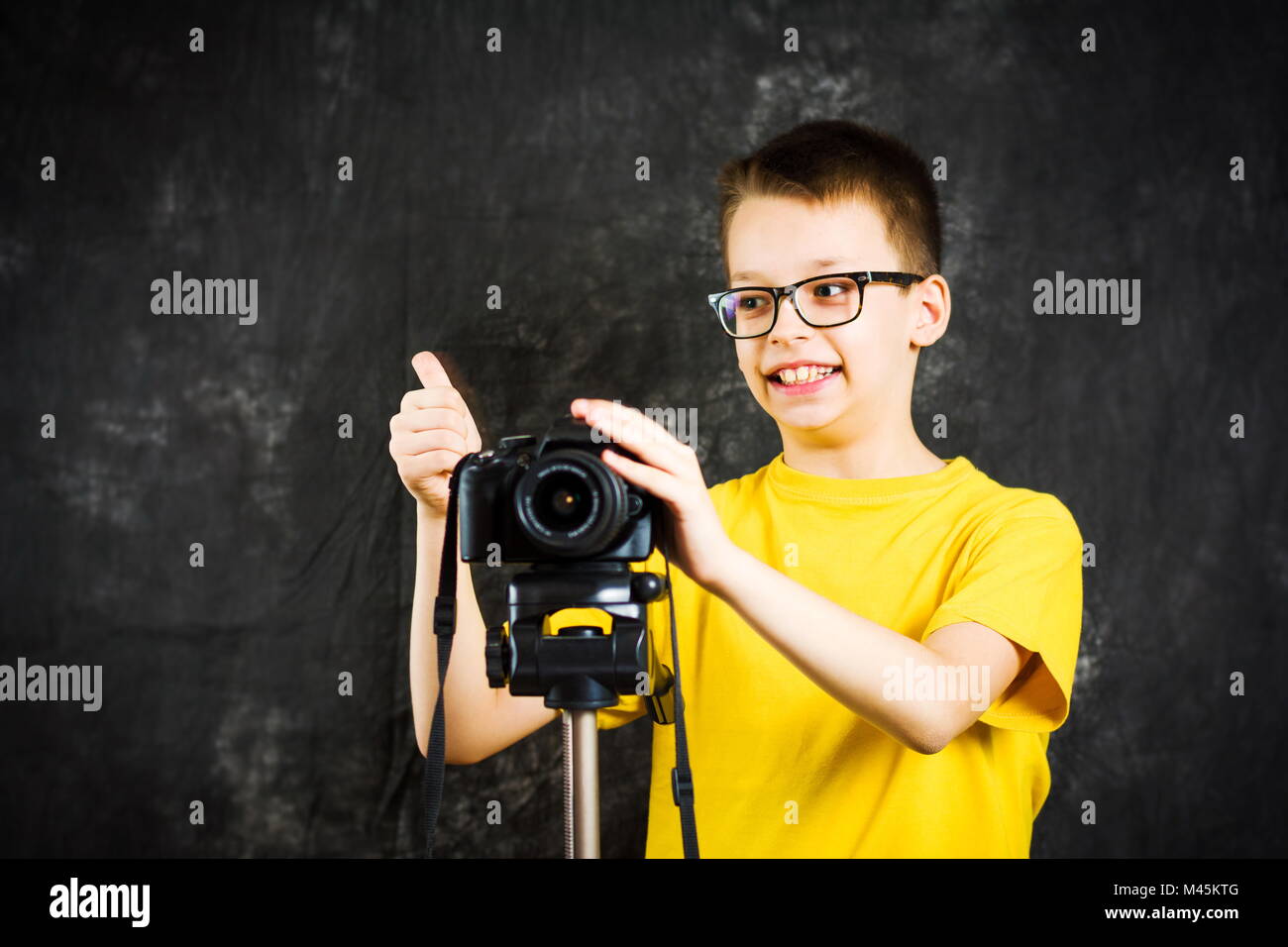 Teenage boy learning how to use a big digital camera Stock Photo