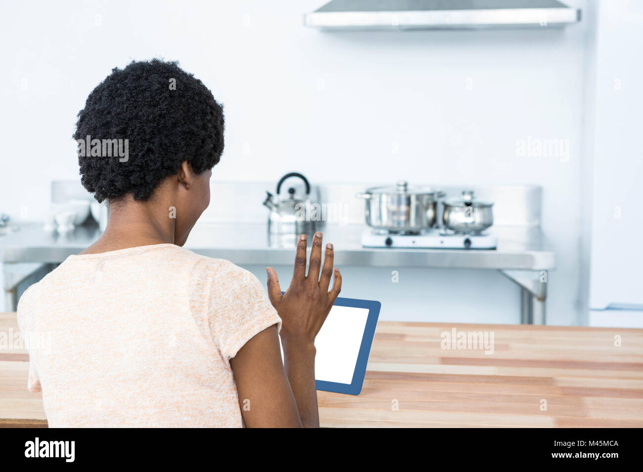 Pregnant woman using digital tablet in kitchen Stock Photo