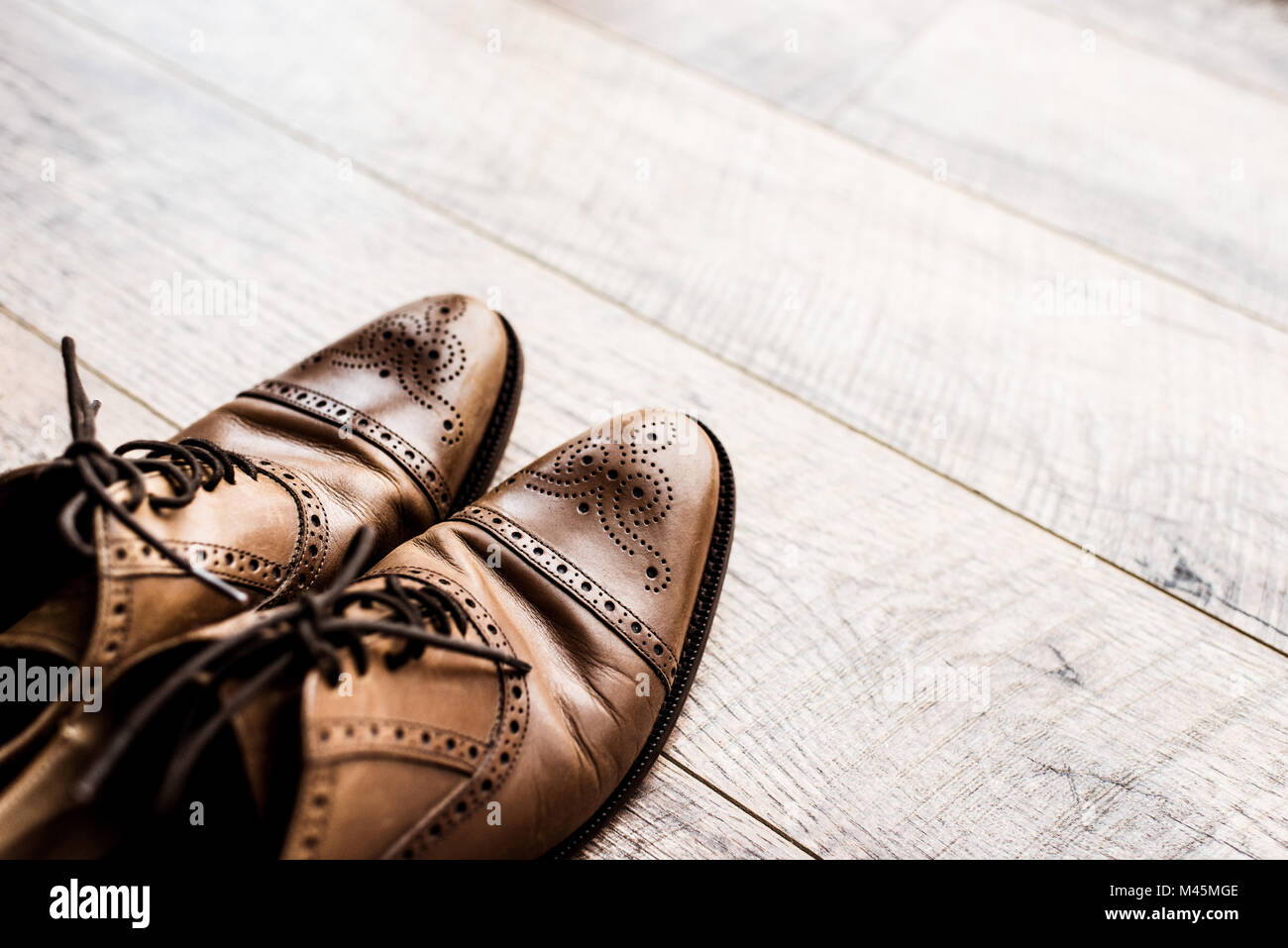 pair of leather brown shoes on wooden floor Stock Photo - Alamy