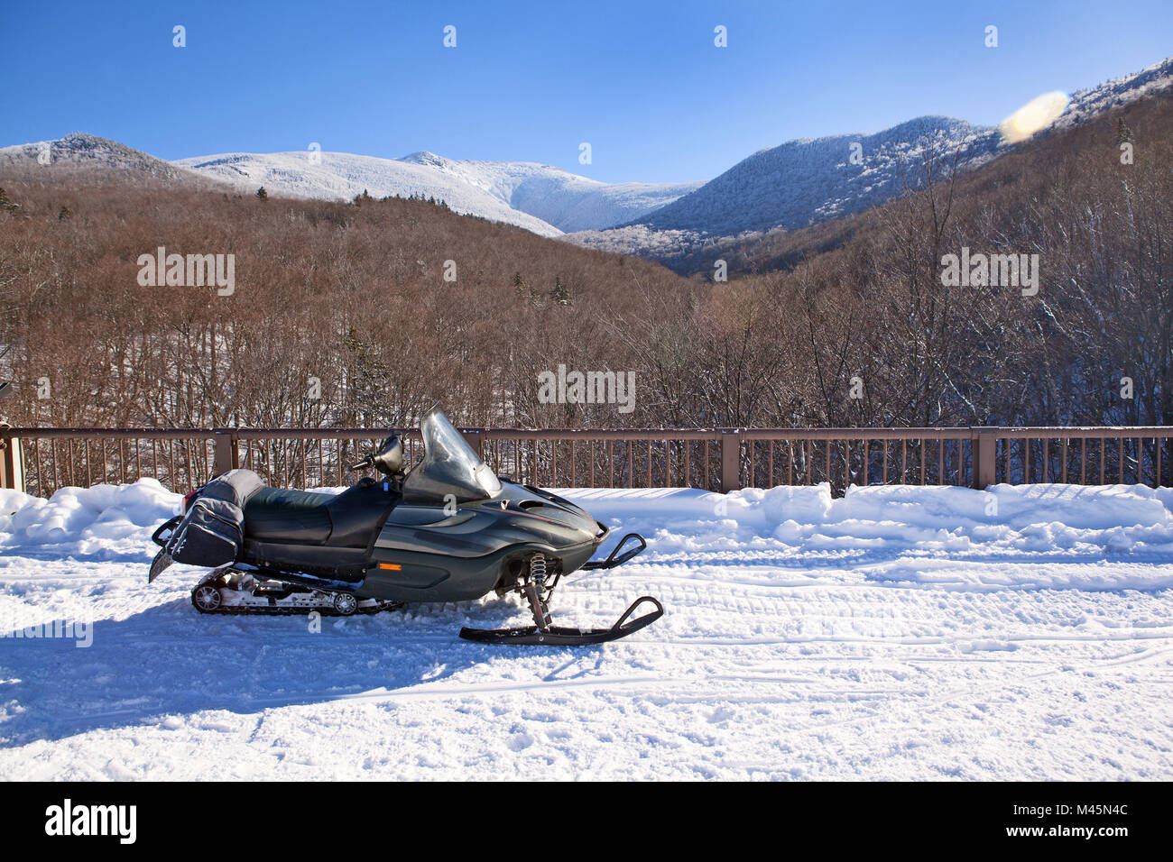 A snowmobile is parked alongside a popular trail in the White Mountains of New Hampshire in Franconia. Stock Photo