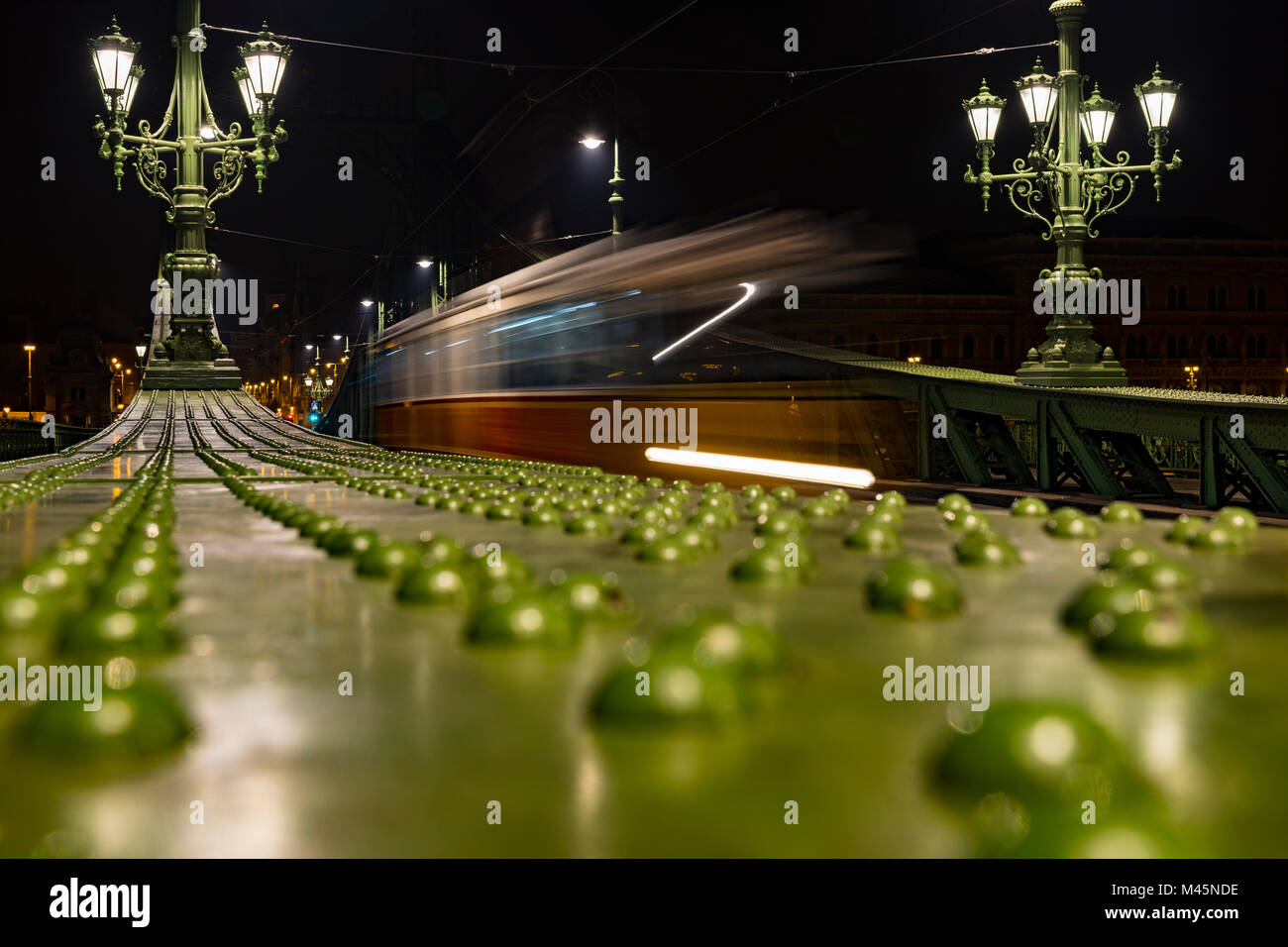 Parapet of the Liberty Bridge with driving tram at night,Budapest,Hungary Stock Photo
