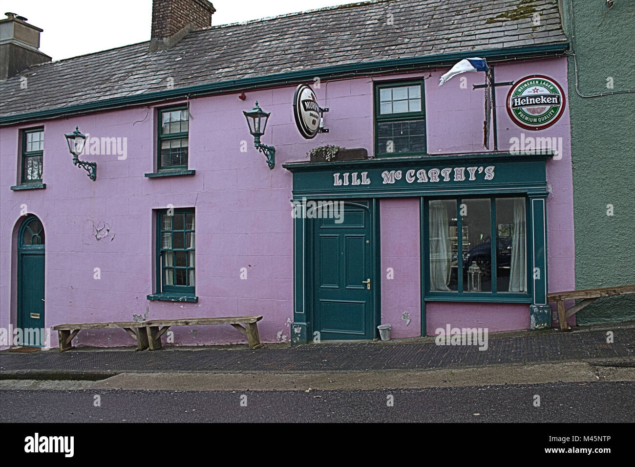 Public House on a steep hill in S/W Ireland. The Benches follow the line of the hill!!. Stock Photo