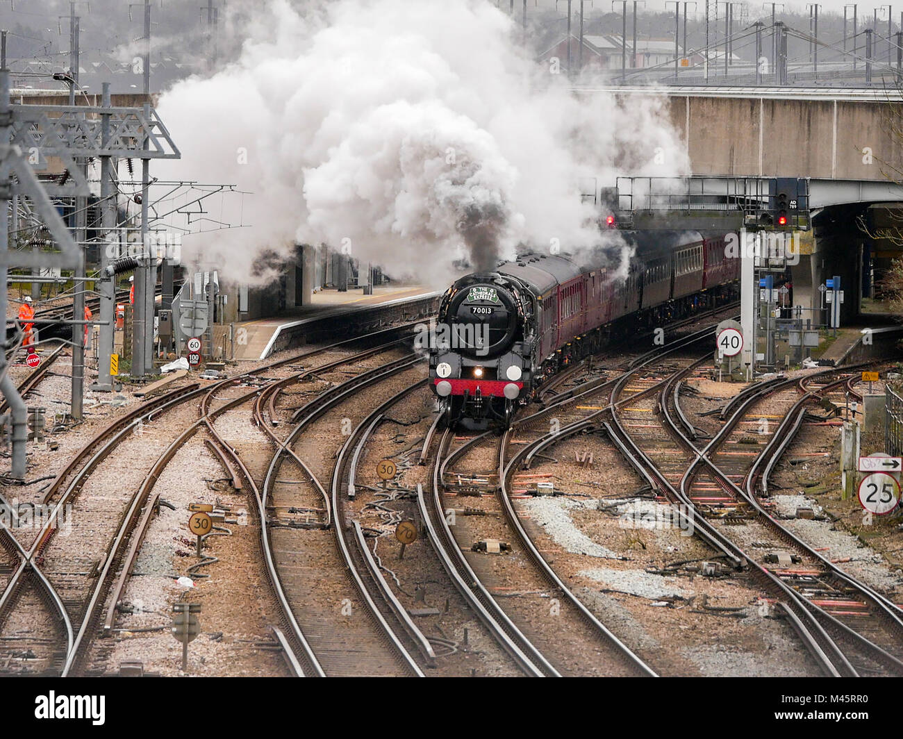 The Cathedrals Express pulled by Oliver Cromwell 70013 locomotive passes through Ashford International Train Station, Kent, UK Stock Photo