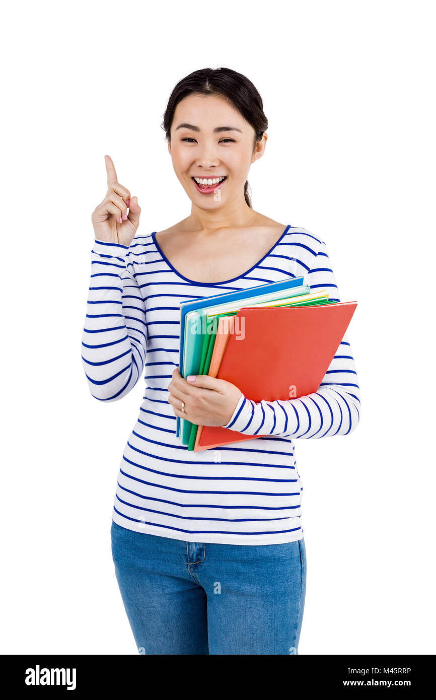 Cheerful woman pointing up while holding files Stock Photo