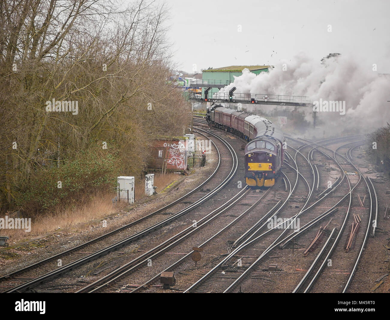 The Cathedrals Express pulled by Oliver Cromwell 70013 locomotive passes through Ashford International Train Station, Kent, UK Stock Photo