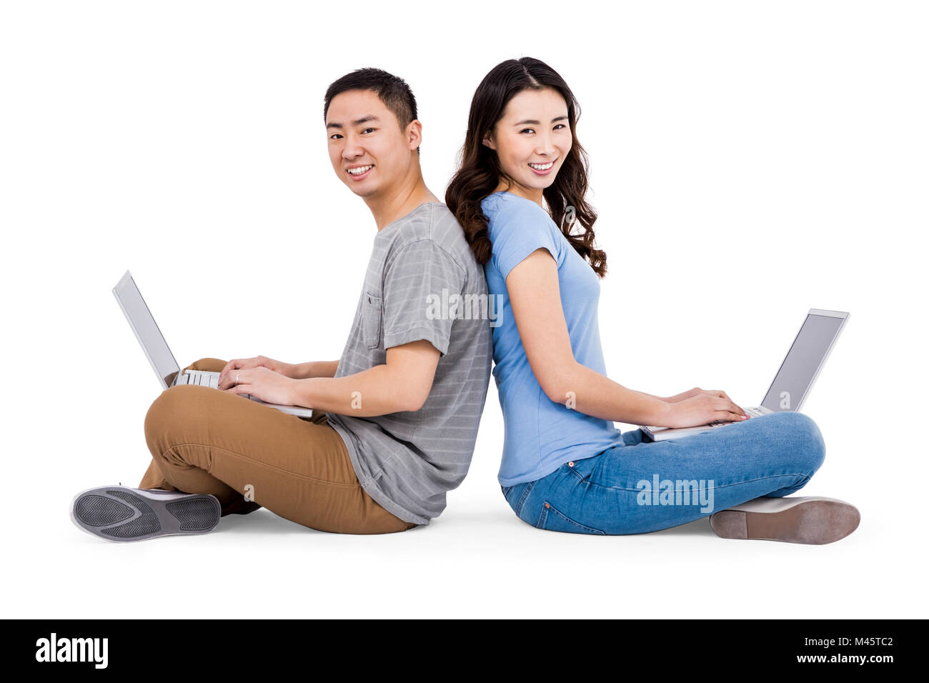 Portrait of young happy couple using laptop while sitting Stock Photo ...