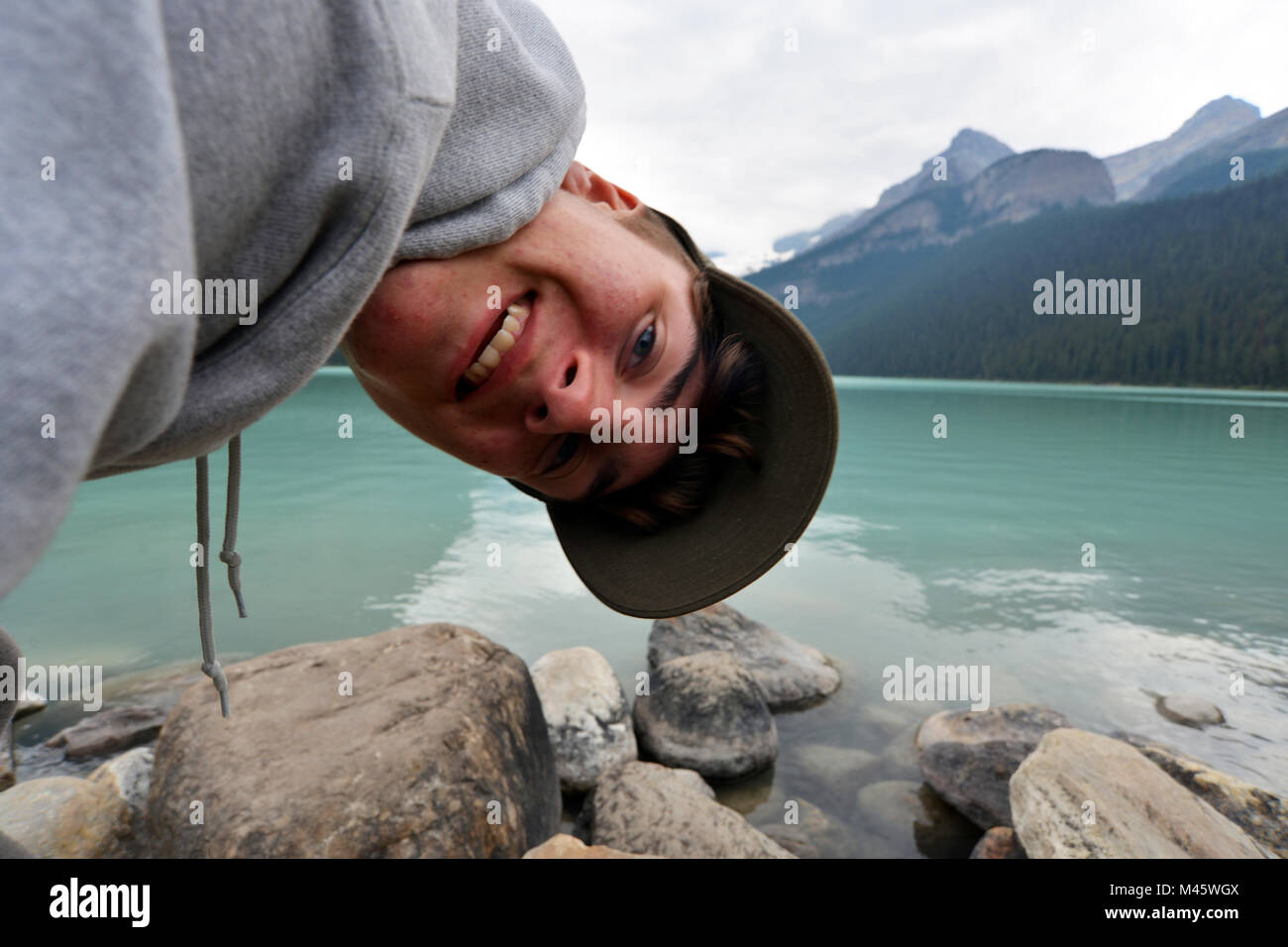 Teenage boy photo bombs the Lake Louise landscape on a family holiday, Canadian Rockies Stock Photo