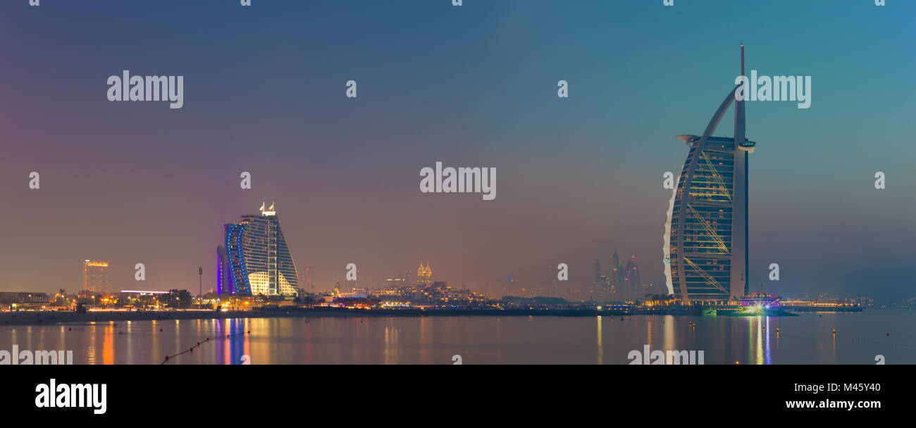 DUBAI, UAE - MARCH 30, 2017: The evening skyline with the Burj al Arab and Jumeirah Beach Hotels. Stock Photo