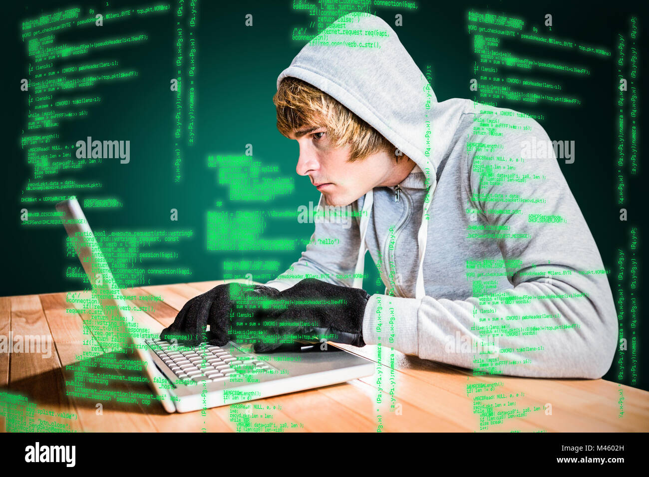 Composite image of focused man with hoodie typing on laptop Stock Photo