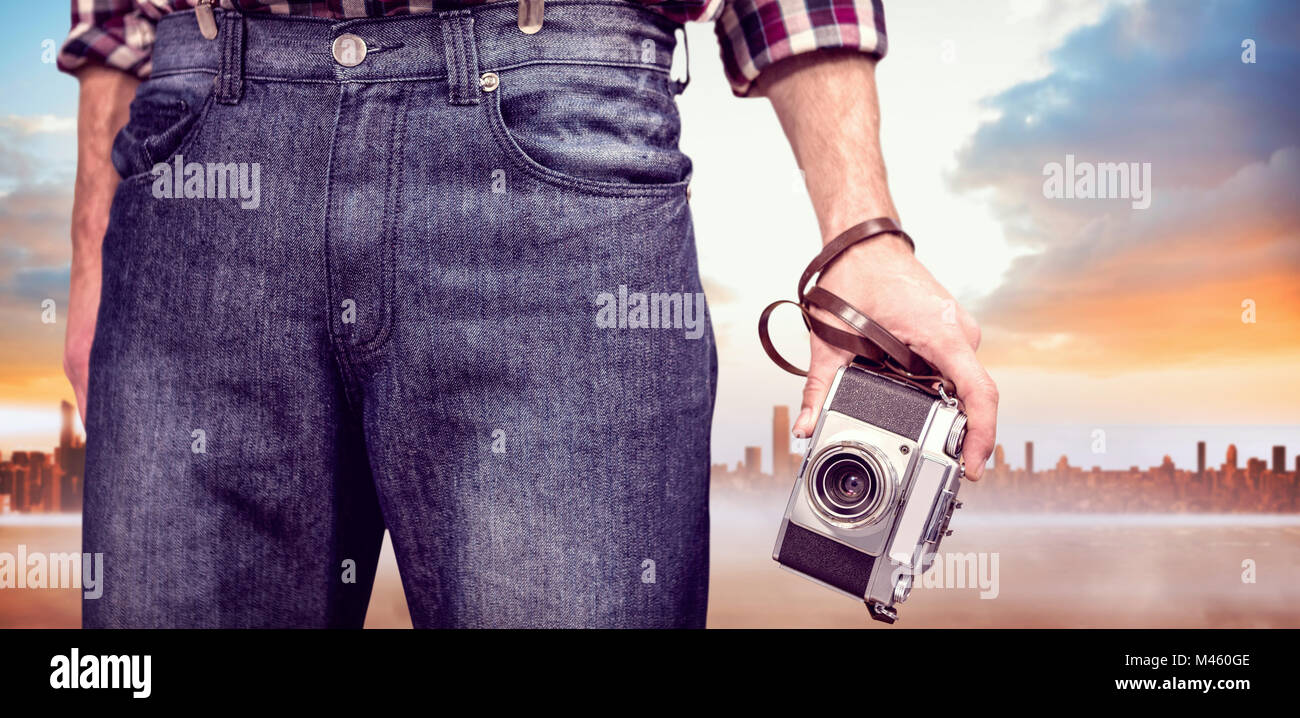 Composite image of hipster man holding digital camera Stock Photo