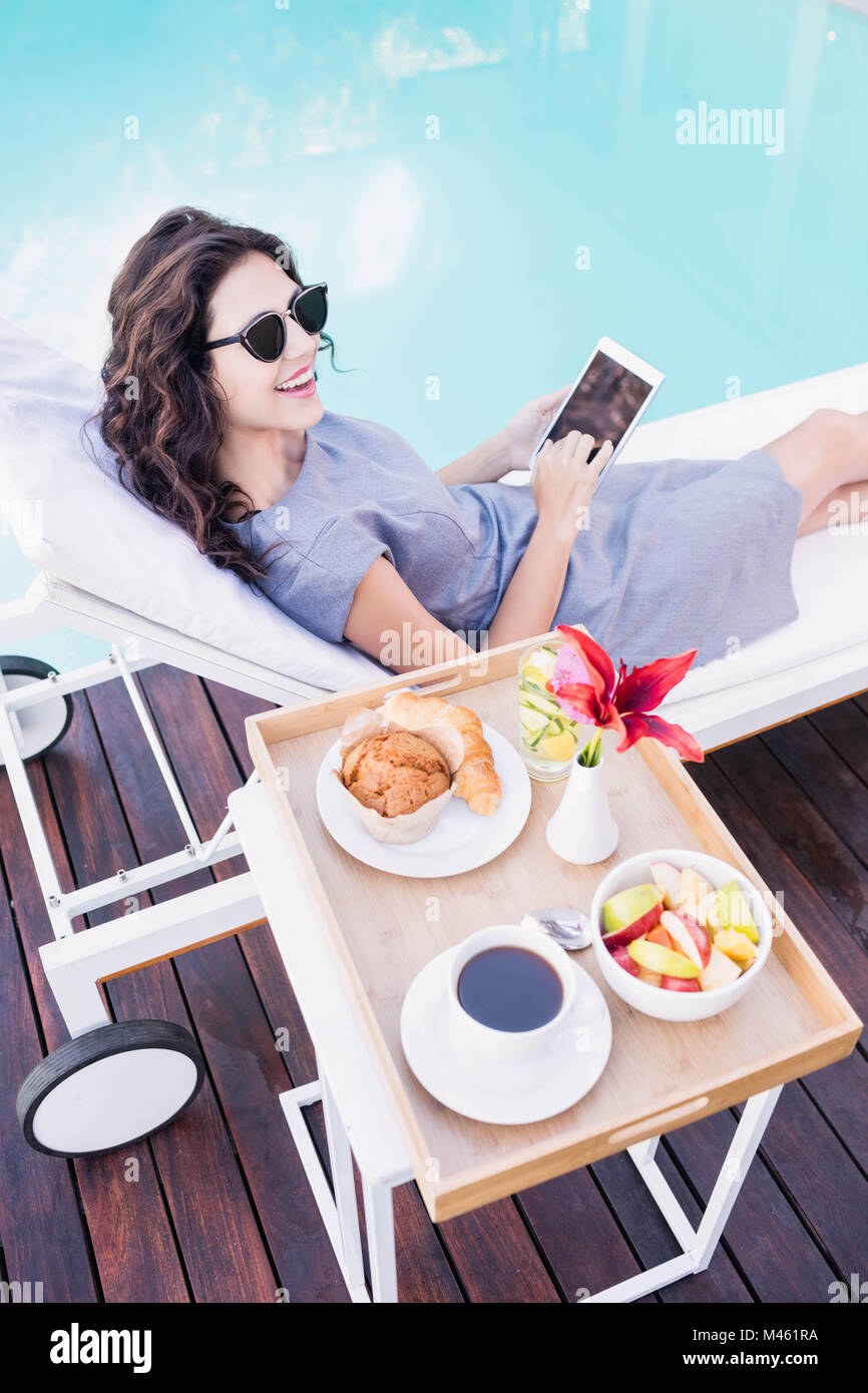 Young woman relaxing on a sun lounger near poolside Stock Photo - Alamy