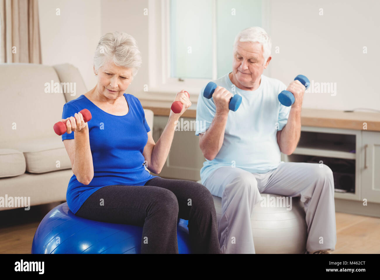 Senior couple sitting on fitness balls with dumbbells Stock Photo - Alamy