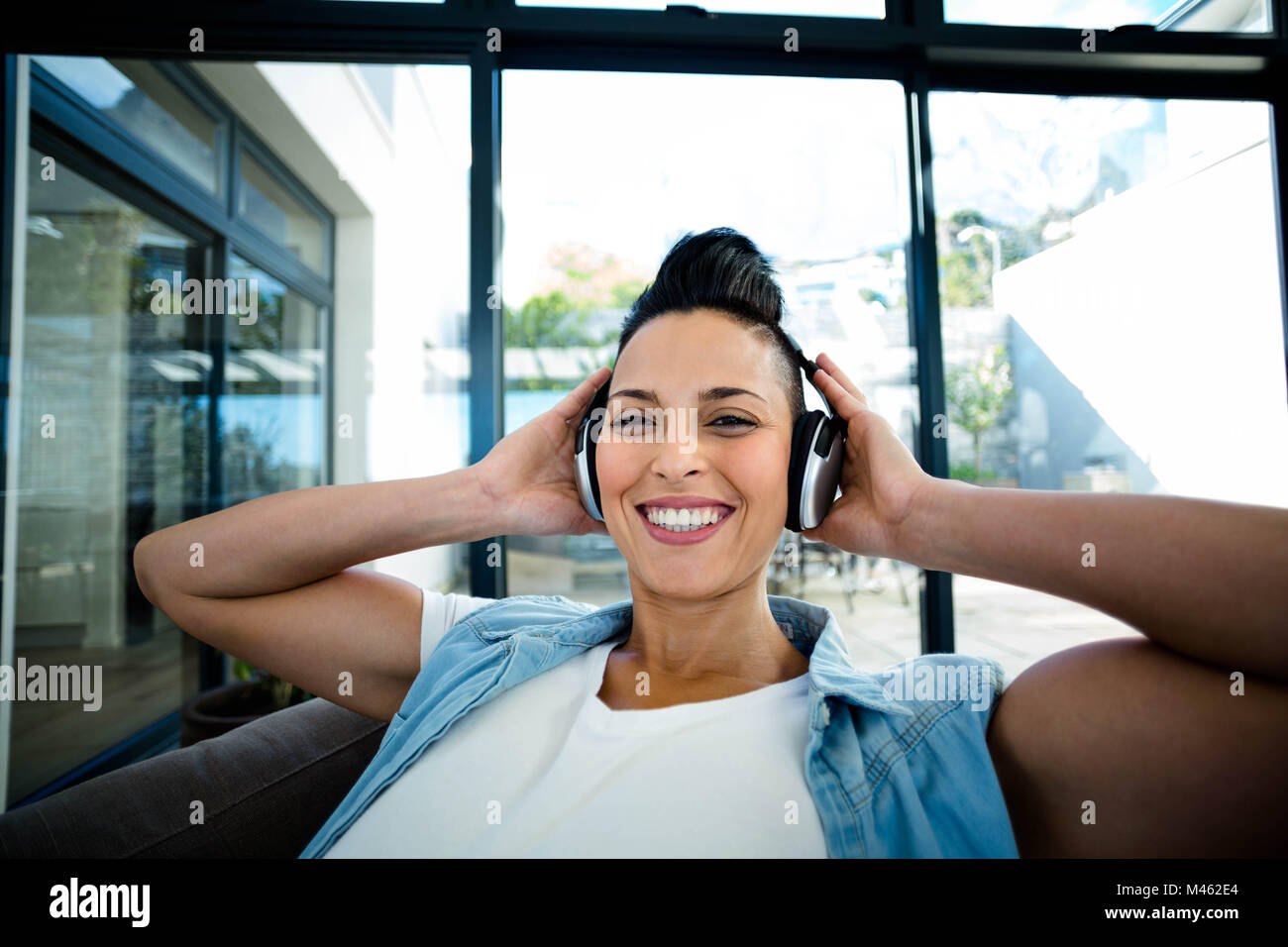 Portrait of pregnant woman listening to music on sofa Stock Photo - Alamy
