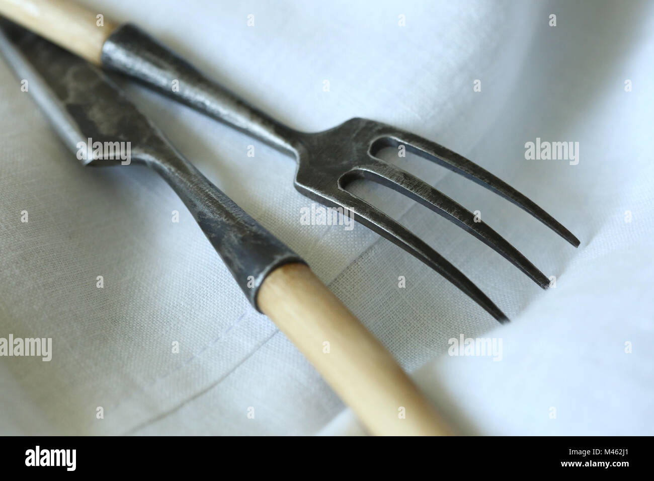 tableware, cutlery, amusement concept. close up of ancient silverware that became very dark with time on the background of snowy white napkin Stock Photo