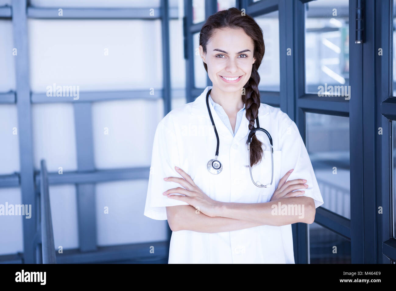 Happy female doctor standing with arms crossed Stock Photo - Alamy