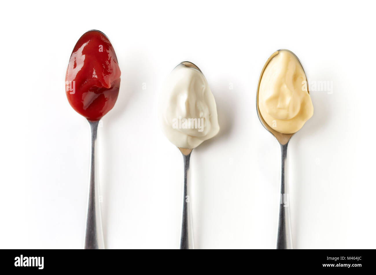 Sour cream, ketchup and mayonnaise in spoon, isolated on white