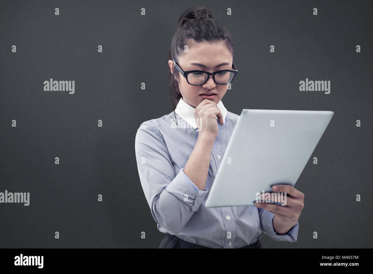 Composite image of asian businesswoman using tablet Stock Photo