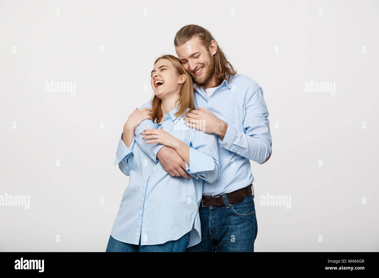 Portrait of cheerful young couple standing and hugging each other on ...
