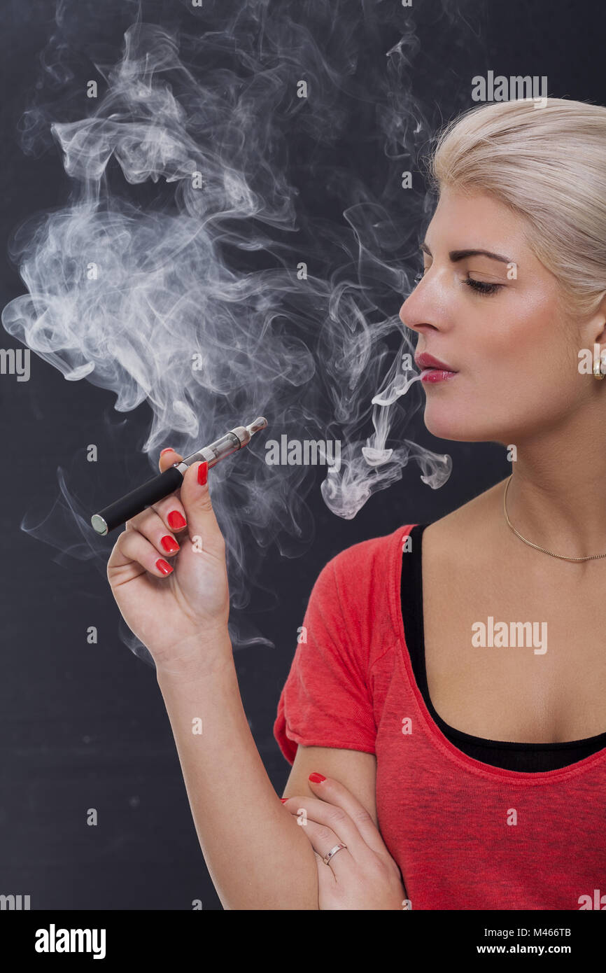 Stylish blond woman smoking an e-cigarette Stock Photo