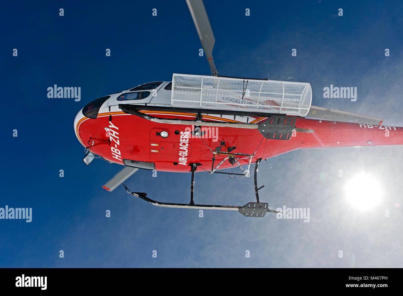 Heliskiing, Air Glaciers helicopter Eurocopter AS 350B3 Ecureuil taking off after dropping skiers on peak Äbeni Flue, Berness Alps, Switzerland Stock Photo