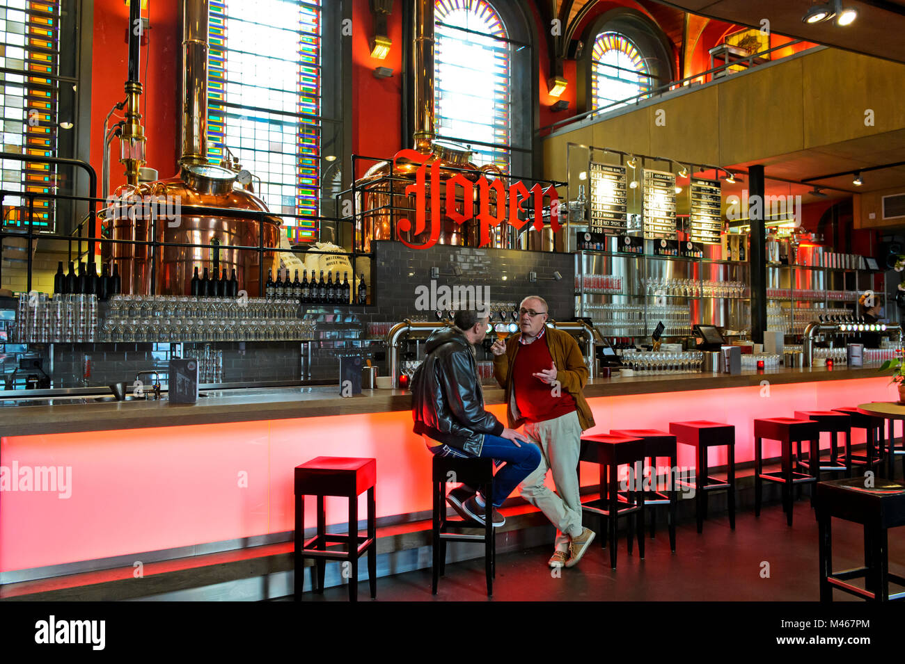 Two guests talking in the taproom of the Jopen brewery in the former church De Jopenkerk, Jopen Church, Haarlem, Netherlands Stock Photo